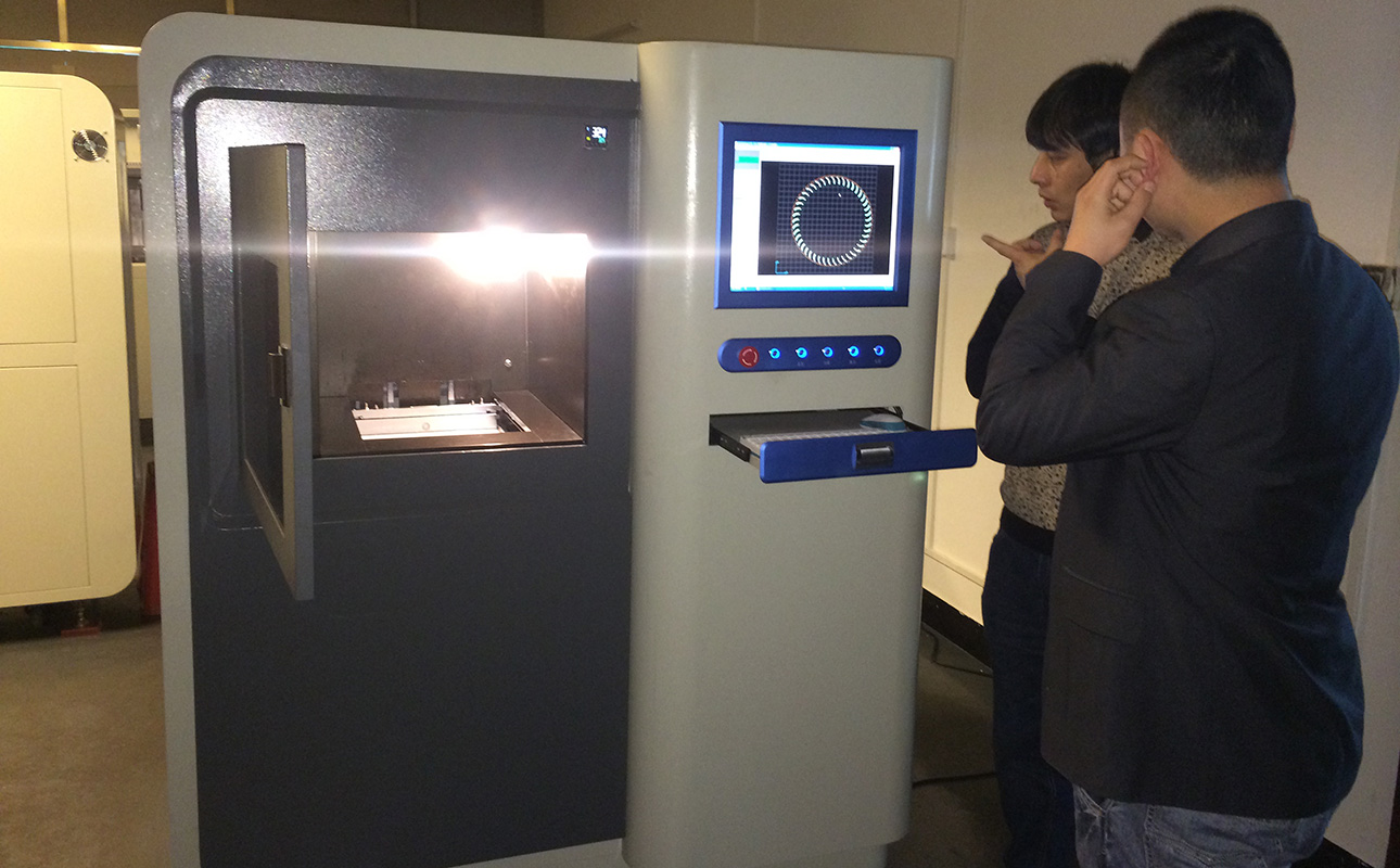 Specialists inspecting a 3D printer