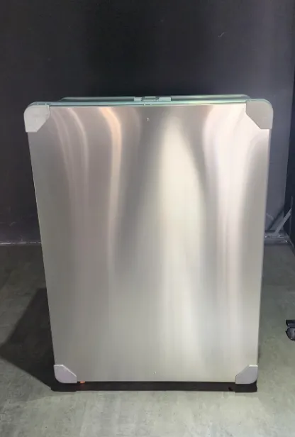 Aluminium Travel Cases Polished silver stainless steel square enclosure with brushed metal finish, white protective corner guards on all four corners, standing on dark floor – industrial control box or server cabinet