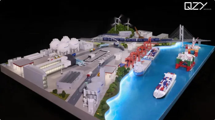 Smart Port & Energy Hub Scale Model – Industrial Logistics Showcase Large-scale illuminated industrial port and energy hub model featuring white spherical storage tanks, wind turbines, cable-stayed bridge with train, red port cranes, cargo ships, container vessels in glowing blue water, roads and facilities – comprehensive smart port & renewable energy masterplan display by QZY Models
