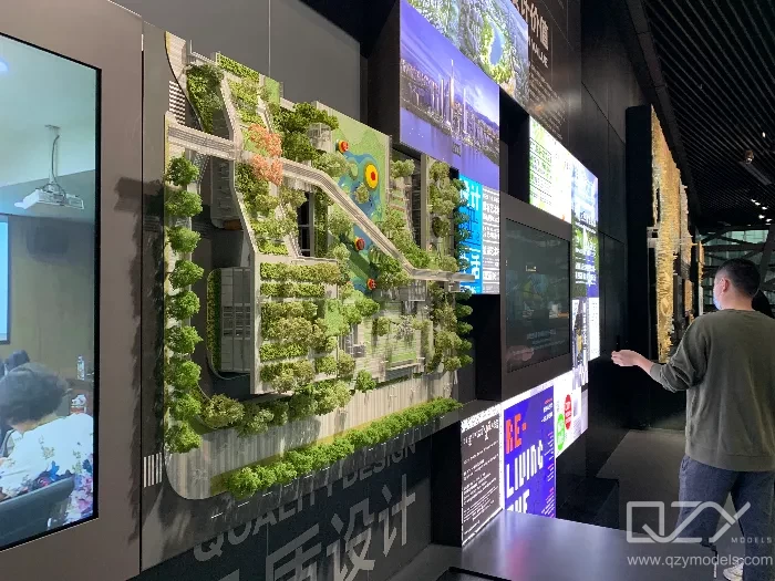 Architect presenting architectural competition scheme to judging panel using scale model