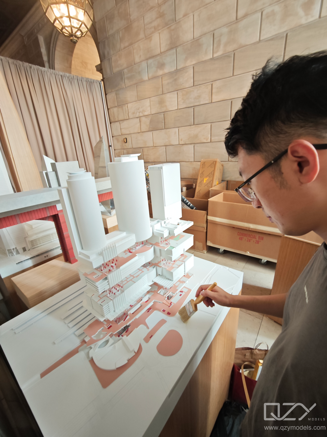 Team cleaning model QZY Models technicians installing architectural scale models for KPF exhibition.