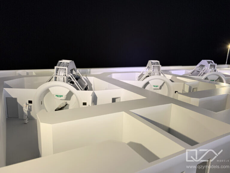 Close-up detail of cancer machine scale model showing precision gantry head surface finish and components